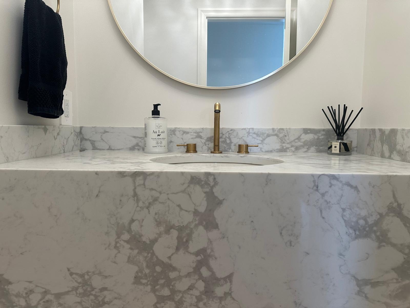 Powder room sink with 3 hole 8" centre faucet in brushed gold with an undermount sink